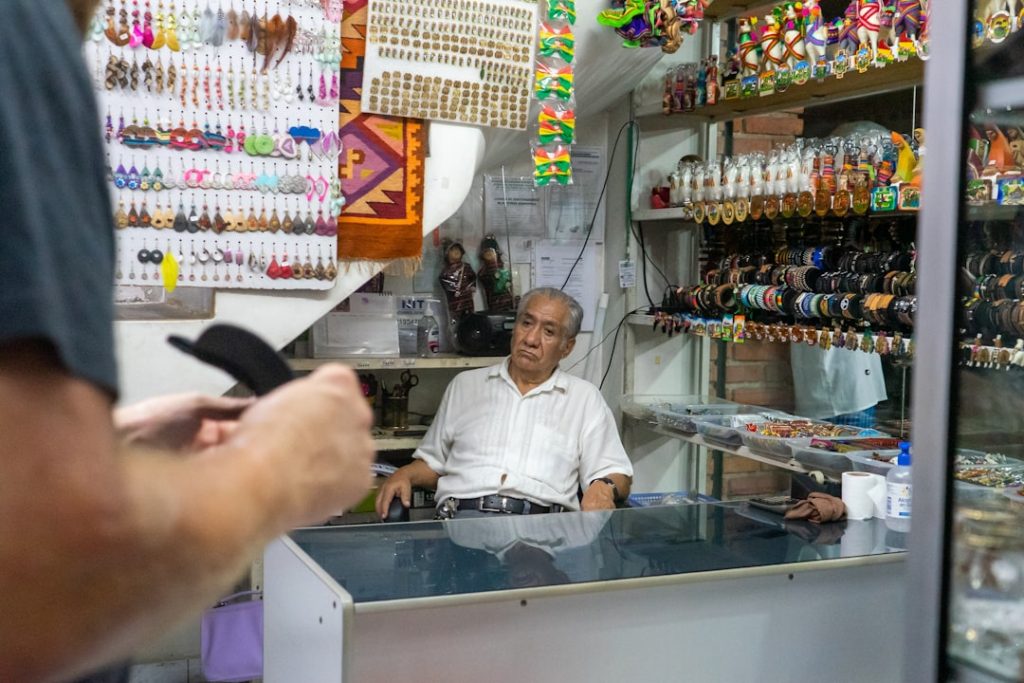 man in white dress shirt standing in front of counter