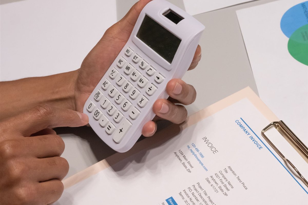 Invoice and calculator on a desk representing project cost planning