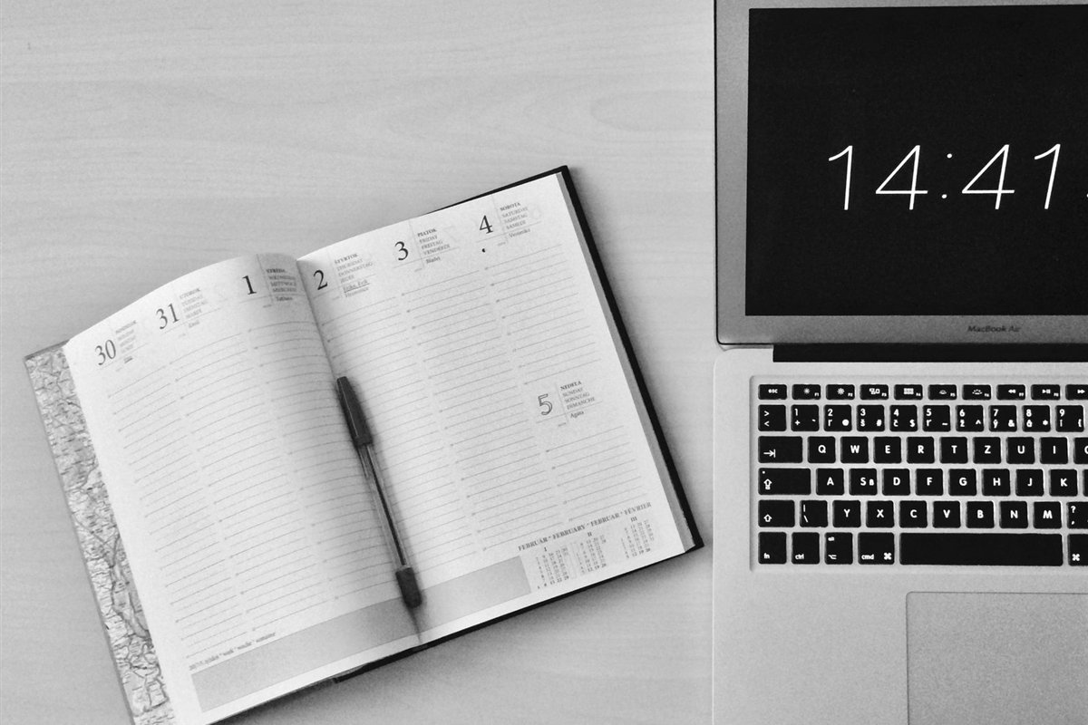 Calendar and laptop on a desk used for planning a project timeline
