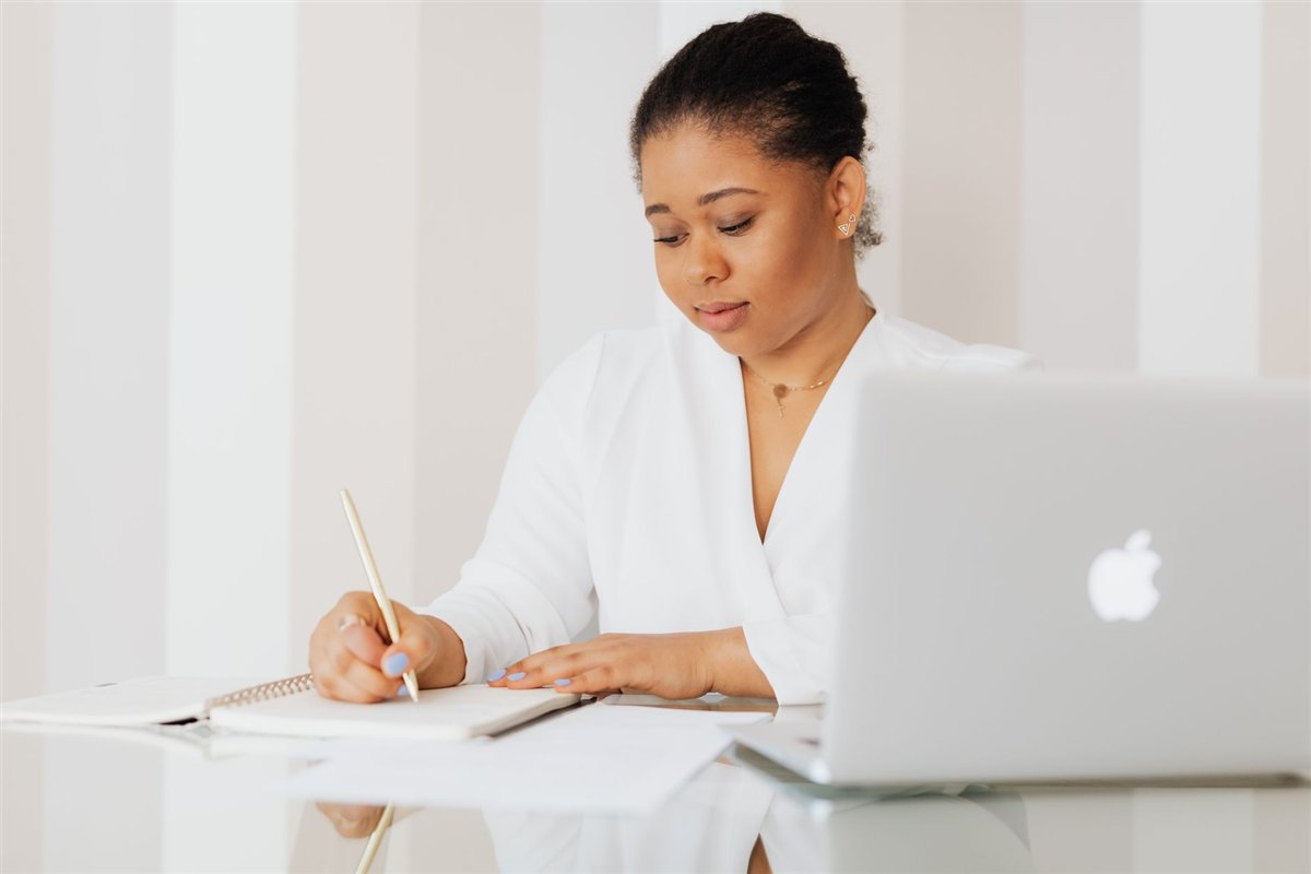 Business owner taking notes on a laptop during a planning meeting