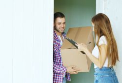 Couple signing for a package delivery at the door